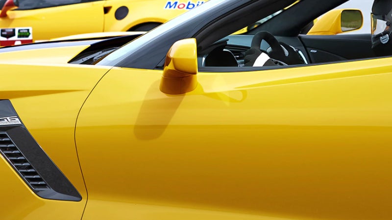 Yellow sports car side panel with a side mirror.
