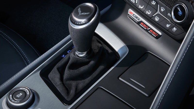 A close-up shot of a car's interior, focusing on the gear shift and part of the dashboard.
