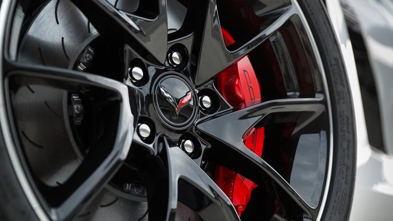 Black alloy wheel with a red brake caliper and Corvette emblem.
