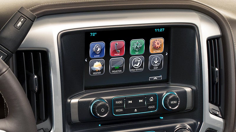 Close-up view of a Chevrolet Silverado infotainment system displaying various app icons on a touchscreen.