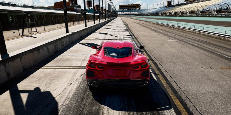 Rear view of a red Chevrolet Corvette on a race track, ready for action.