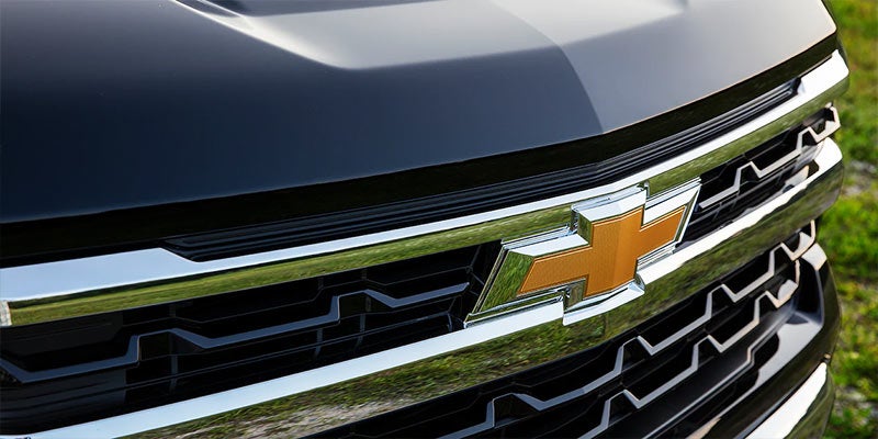 Close-up of a Chevrolet Silverado's front grille featuring the gold Chevrolet bowtie emblem and chrome accents.