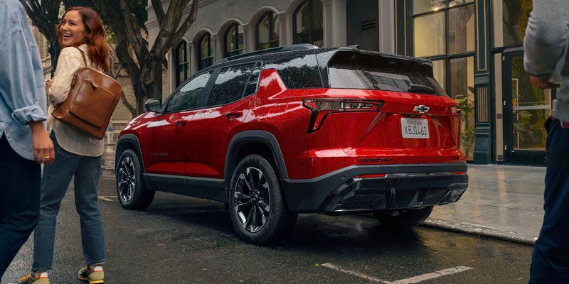 Rear view of a red Chevrolet Equinox RS parked on the street as people walk nearby.