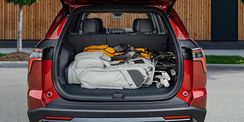 Open trunk of a red Chevrolet Equinox RS, loaded with luggage and outdoor gear.